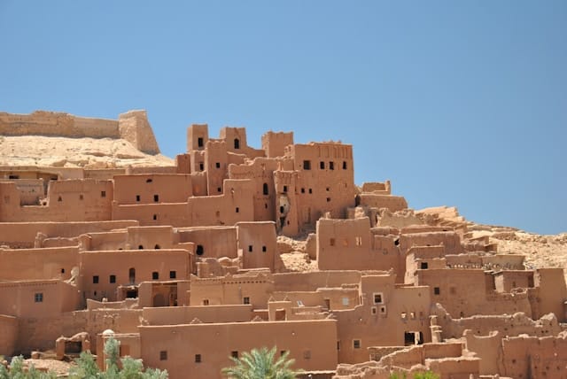 The fortified village of Ait Benhaddou, surrounded by palm trees and mountains, visited during the 10 days in Morocco tour from Casablanca