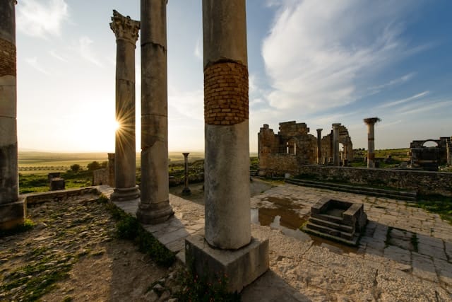 Ancient Roman ruins at Volubilis, featuring well-preserved columns and mosaics during the 10 days in Morocco tour from Casablanca.