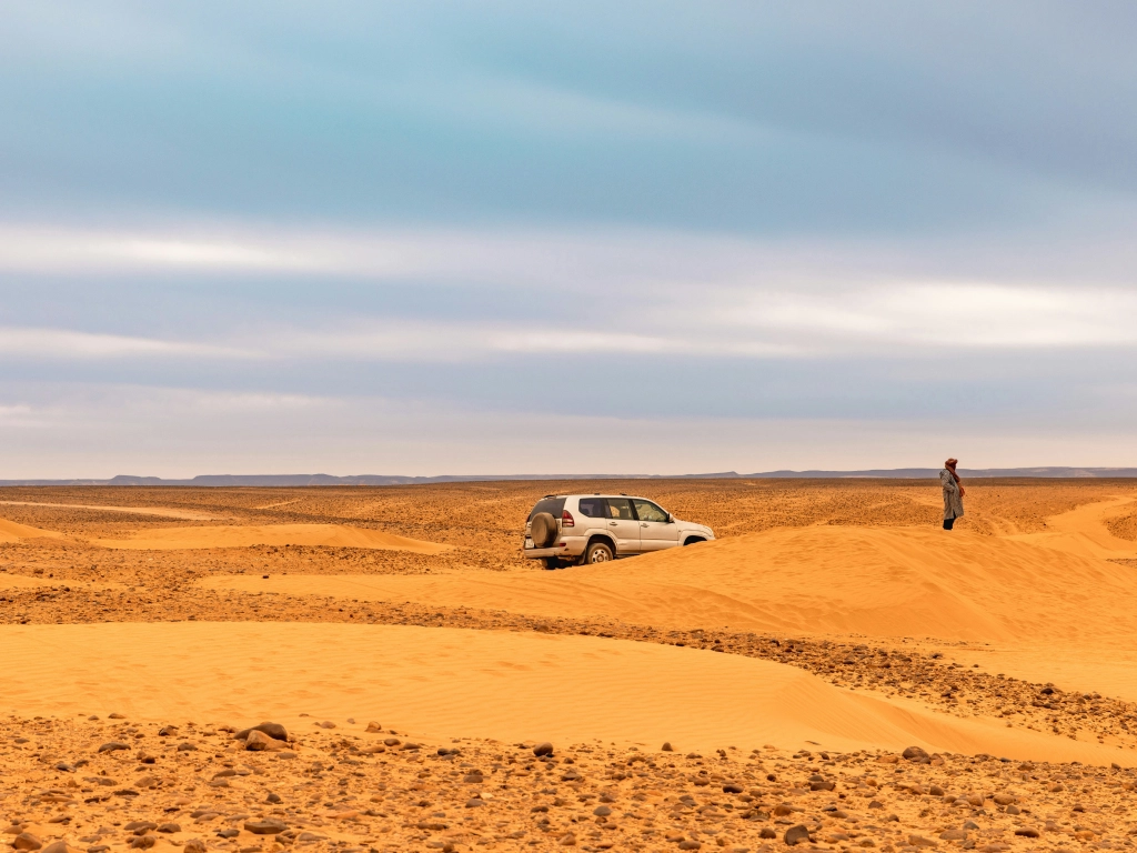 Black desert volcanic landscape near Merzouga with 4x4 vehicle