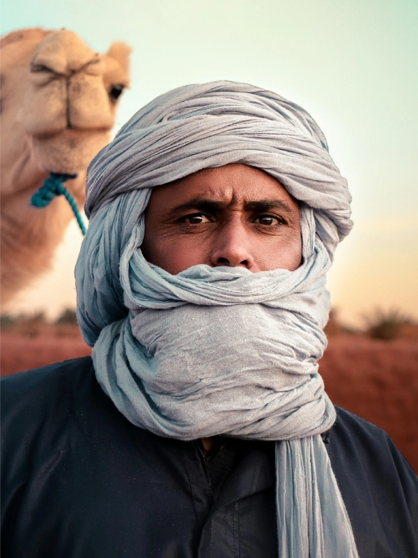 Ali, a desert guide leading a Dromedary trek through the Sahara dunes.