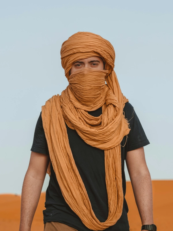 Hamid, the founder of Travel Via Morocco, standing in the Merzouga desert dunes.