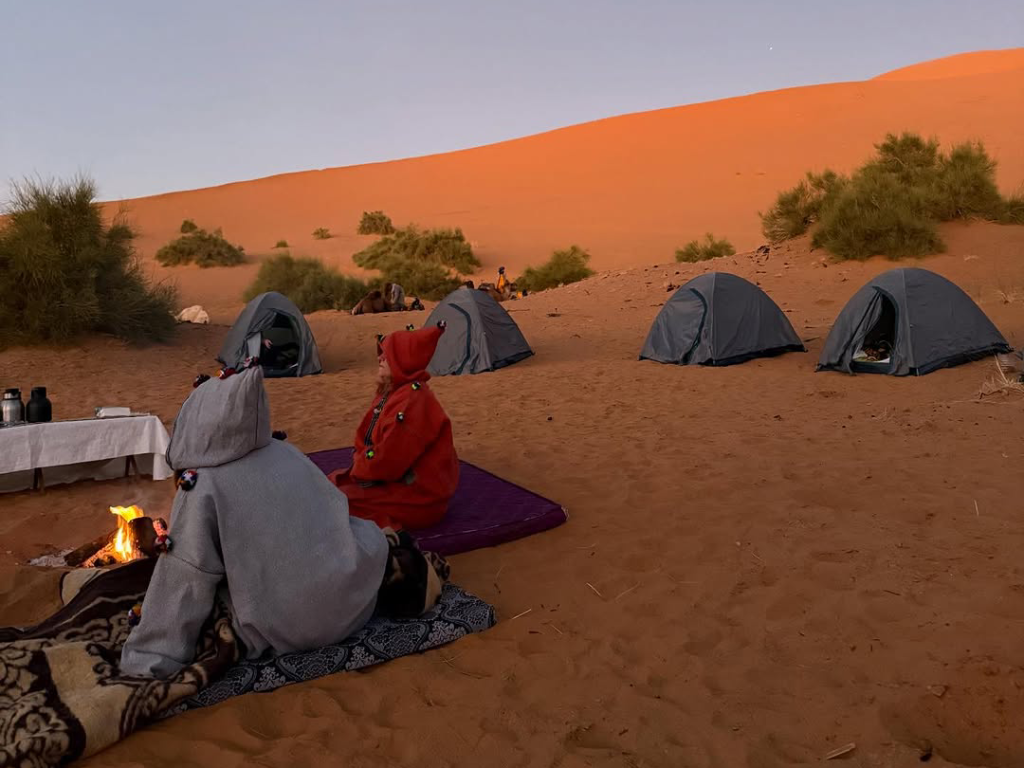 Secluded Merzouga overnight camp nestled between tall sand dunes away from tourist crowds