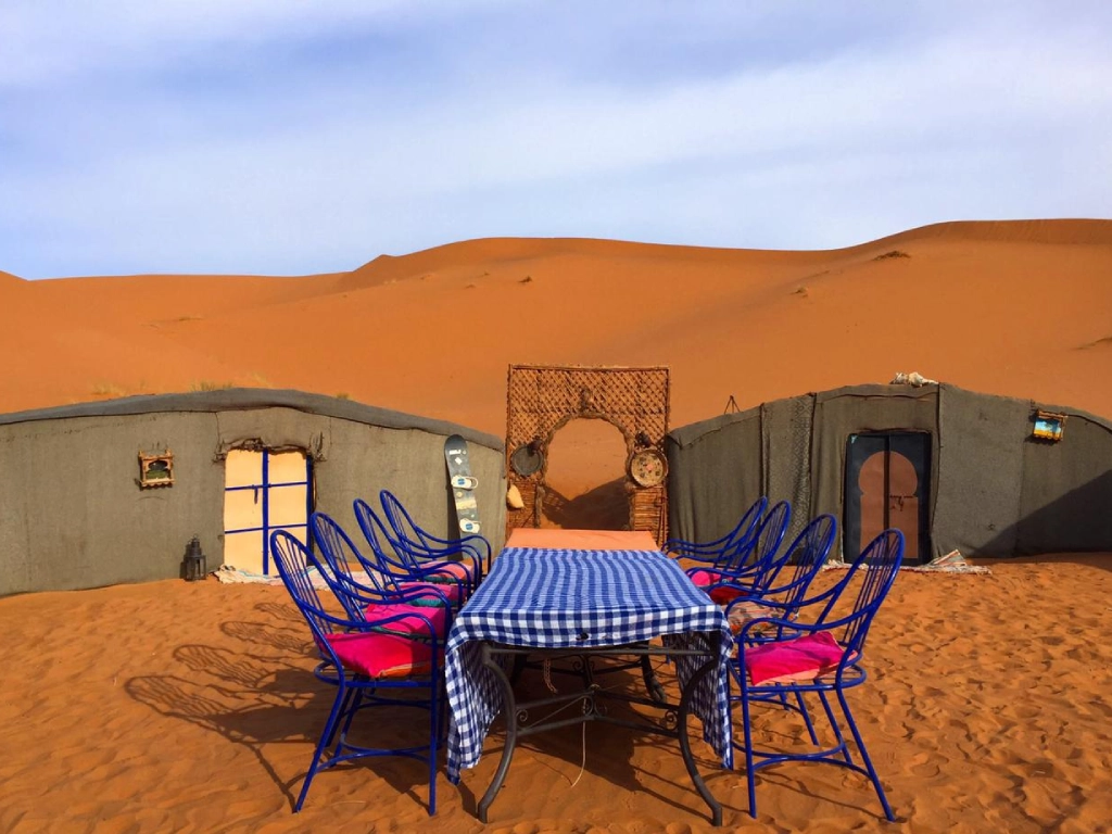 Traditional Berber camp in Merzouga with simple tents arranged around central campfire area