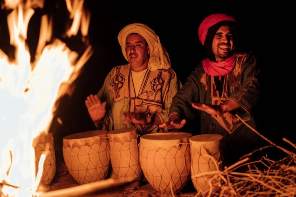 Traditional Berber music performance around campfire during wild camping Morocco experience