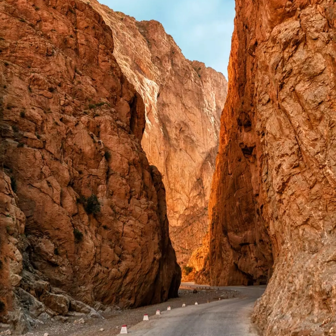 4 days desert tour from Marrakech — Todra Gorge interior with 300-metre orange limestone canyon walls and herder with goats Morocco